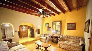 A cozy living room with floral-patterned sofas, a wooden coffee table, and a ceiling fan. - Casa en Parras de la Fuente (Parras de la Fuente)