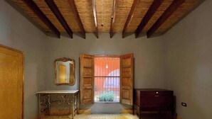 A bedroom with a bed, a dresser, a mirror, and a window with open shutters. - Casa en Parras de la Fuente (Parras de la Fuente)