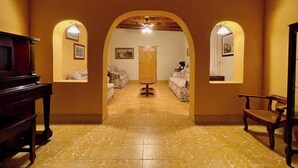 A hallway with a wooden floor, two sofas, a wooden cabinet, and a piano. - Casa en Parras de la Fuente (Parras de la Fuente)