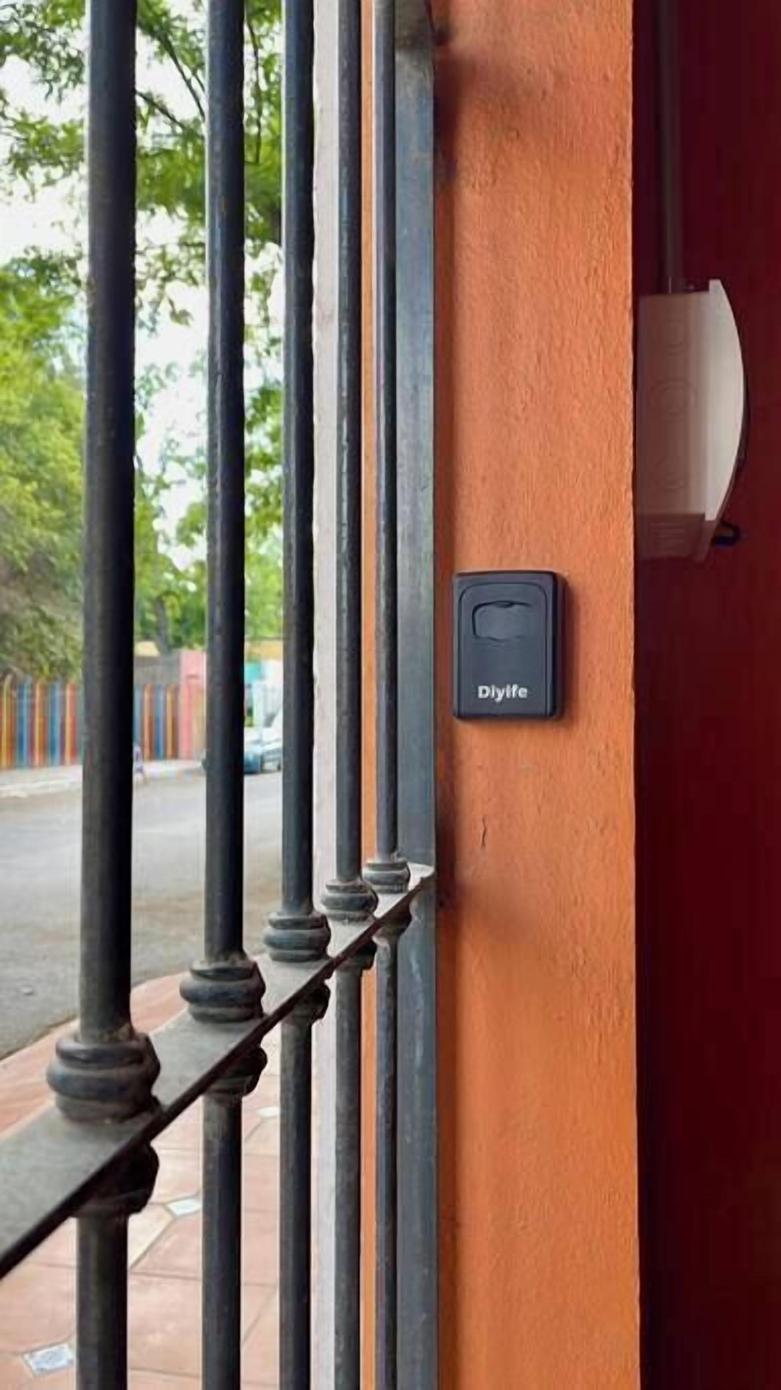 Une porte dotée d’un dispositif de sécurité noir portant l’inscription « Dylife », fixée sur un mur orange.