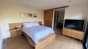 A bedroom with a bed, wooden nightstands, a TV, and framed pictures on the wall. - Suite Oyamel en Valle de Bravo (Valle de Bravo)