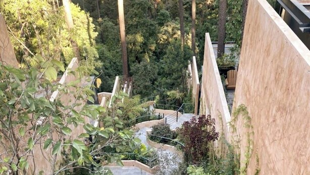 A view of a lush garden with a stone pathway leading to a wooden deck. - Suite Oyamel en Valle de Bravo (Valle de Bravo)