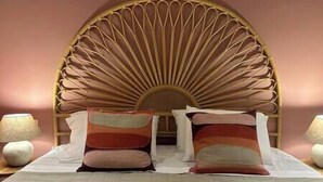 Ein Bett mit Holz-Kopfstück, zwei Kissen und Nachttischlampen.