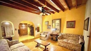 A living room with a ceiling fan, two sofas, a coffee table, and a dining table.