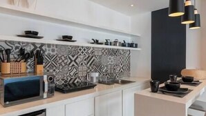 A modern kitchen with a patterned backsplash, a microwave, and a sink. - Loft Chic en el Corazón de la CDMX Centro (Cuauhtémoc)