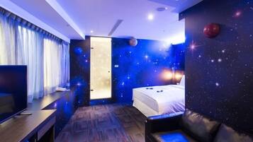 Une chambre d’hôtel avec un lit, une télévision, un bureau et un canapé en cuir.