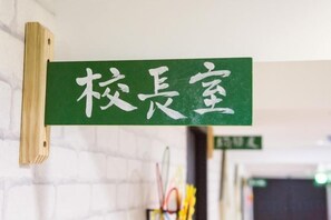 A green sign with white Chinese characters hanging on a wall. - RF Hotel - Sanchong (New Taipei City)