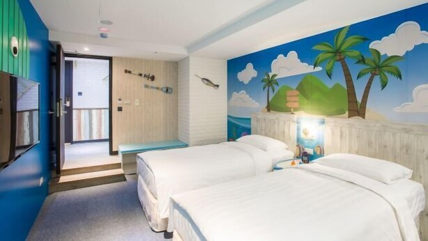 A hotel room with two beds, a mural of a beach scene, and a wooden door leading to a balcony. - RF Hotel - Sanchong (New Taipei City)