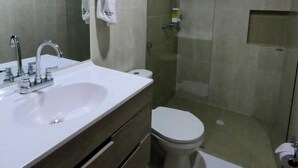 Ein modernes Badezimmer mit großem Spiegel, zwei Waschbecken, Toilette und Duschbereich.