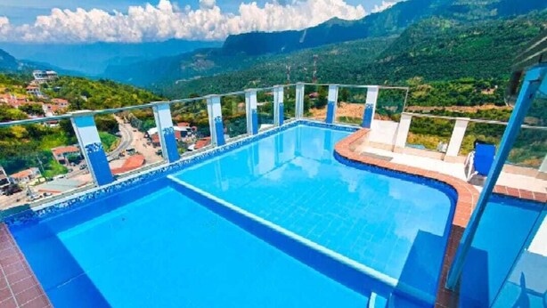 Ein großer Pool im Freien mit freiem Blick auf die umliegende Landschaft und Berge.