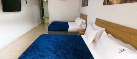 A hotel room with a large bed, a smaller bed, a flat-screen TV, and a painting on the wall.