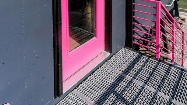 A building with a bright pink door and a black exterior. - One-of-a-Kind Renovated Train Caboose - Hot Tub - Games (Denver)