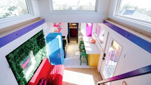 A modern kitchen with a blue refrigerator, green stools, and a pink sink. - One-of-a-Kind Renovated Train Caboose - Hot Tub - Games (Denver)