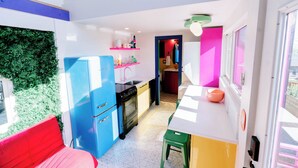A compact kitchen with a blue refrigerator, a sink, and a microwave. There is a green stool and a red bench. - One-of-a-Kind Renovated Train Caboose - Hot Tub - Games (Denver)
