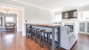 Een moderne keuken met een bar, een grijze bank en een open haard.