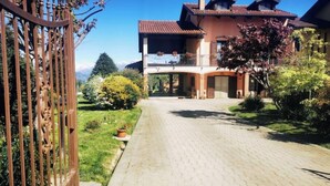 Une allée pavée menant à une maison dotée d’un balcon.