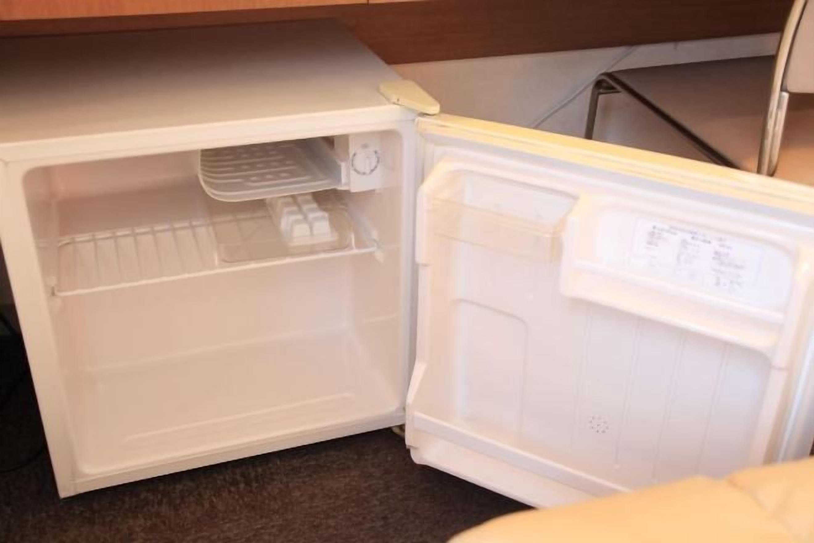 Ein offener Kühlschrank mit einer Bedienfeld am oberen linken Rand und einem Gefrierfach auf der rechten Seite.