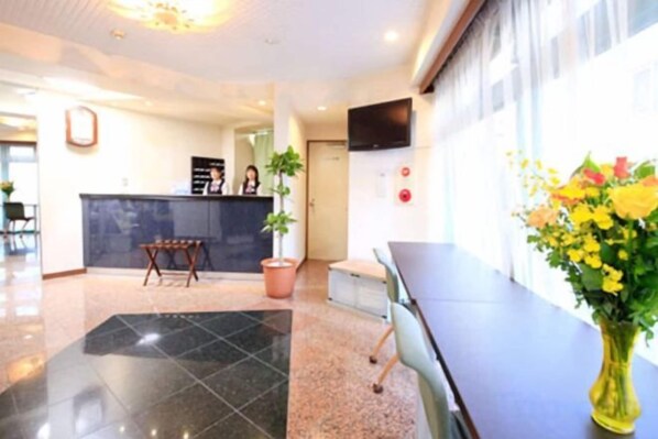 A hotel lobby with a reception desk, seating area, and a large window. - Urban Hotel Tokyo Fuchu East Exit (Fuchu)