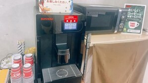 A coffee machine with a digital display and a sign indicating 'FREE COFFEE'.