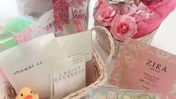 A basket with various items including a duck, a card, and some flowers.