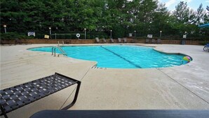 A swimming pool with a diving board, lounge chairs, and a paved deck area. - Lake Hartwell/Clemson University 3 bd/2 bath condo (Anderson)