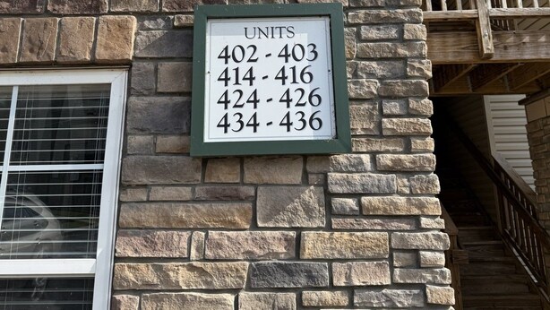 A building with a stone facade and a sign listing apartment numbers 402-403, 414-416, 424-426, and 434-436. - Lake Hartwell/Clemson University 3 bd/2 bath condo (Anderson)