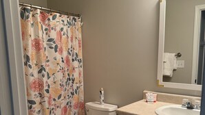 A bathroom with a toilet, a sink, and a shower curtain. - Lake Hartwell/Clemson University 3 bd/2 bath condo (Anderson)