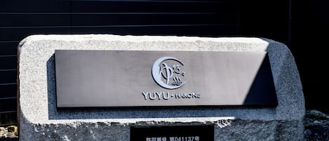 Una placa de piedra con el nombre "YUYU HAKONE" y un número de registro.