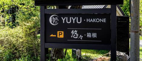 A black sign with "YUYU HAKONE" and a parking symbol.
