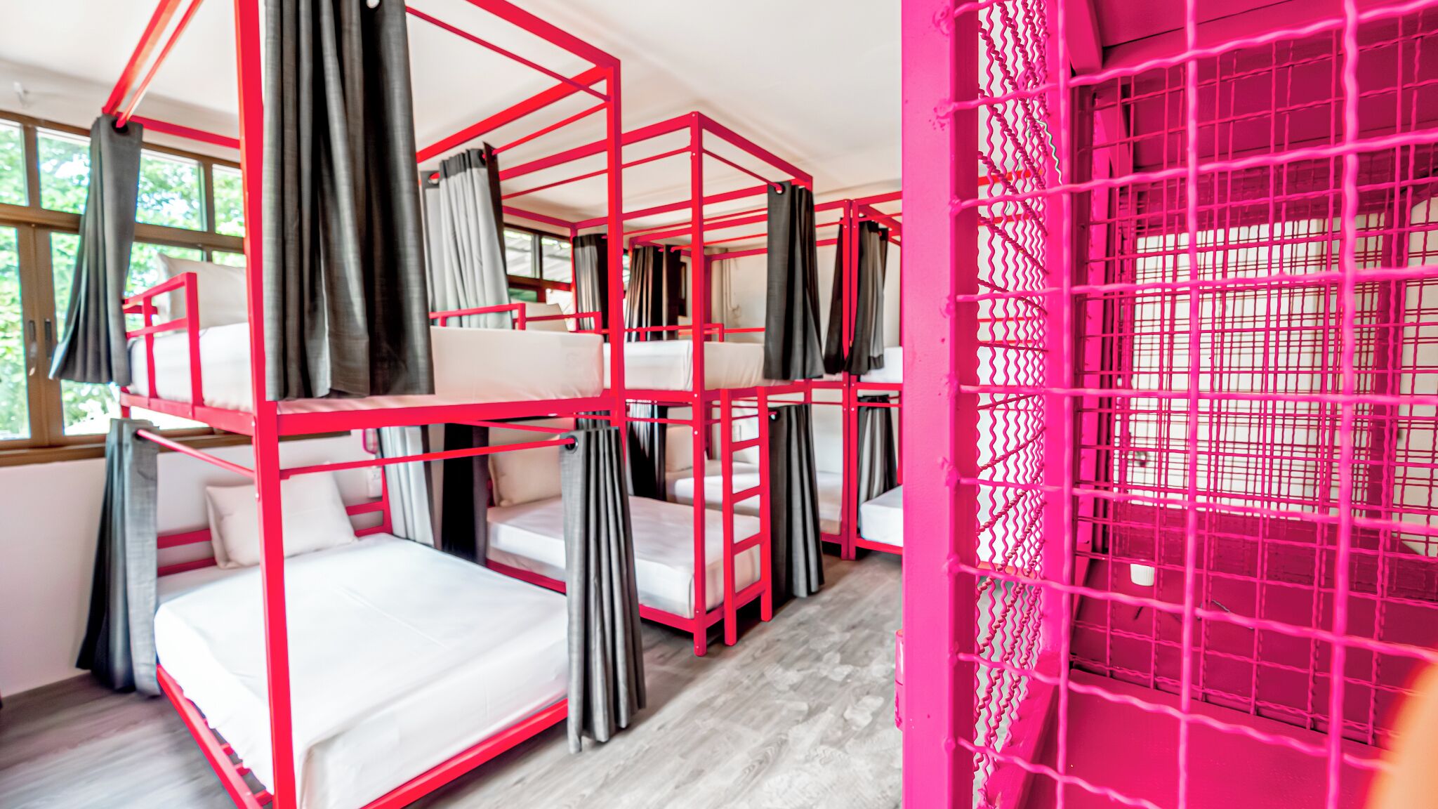 Ein Zimmer mit Etagenbetten und einer rosa Trennwand.