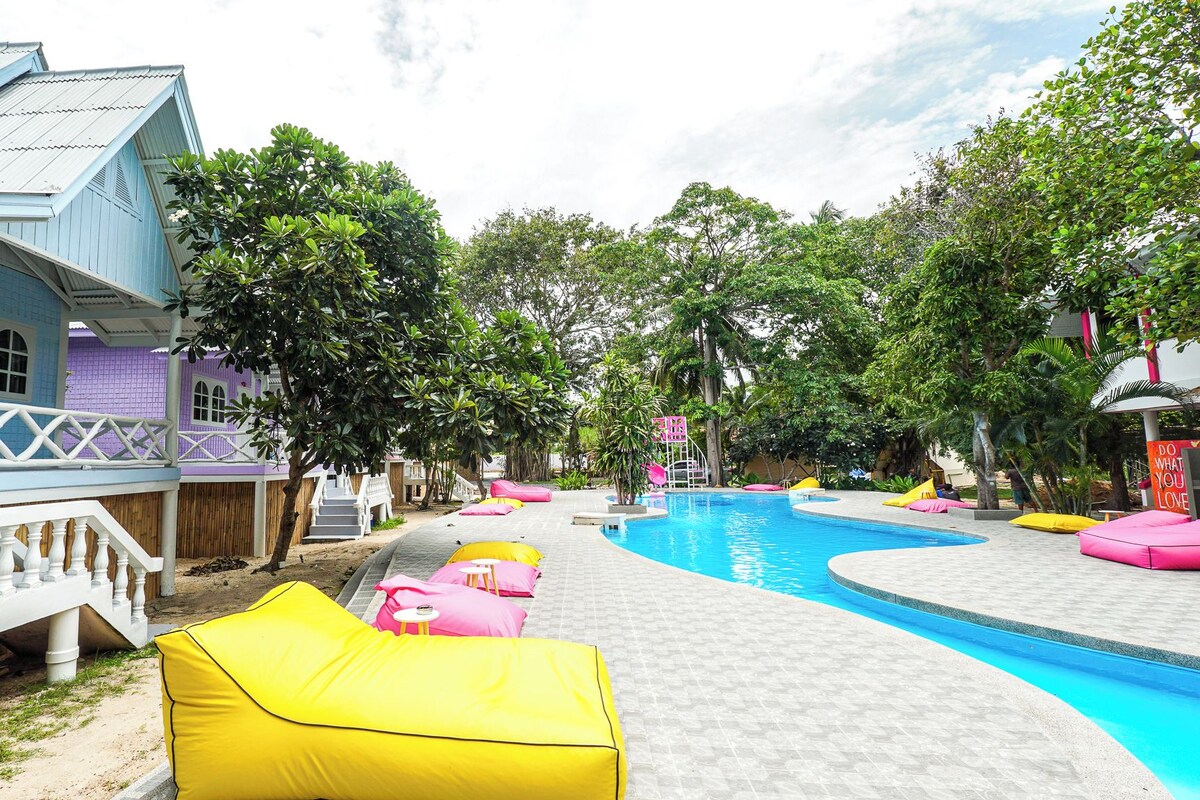 A pool area with colorful lounge chairs and a clear blue pool.