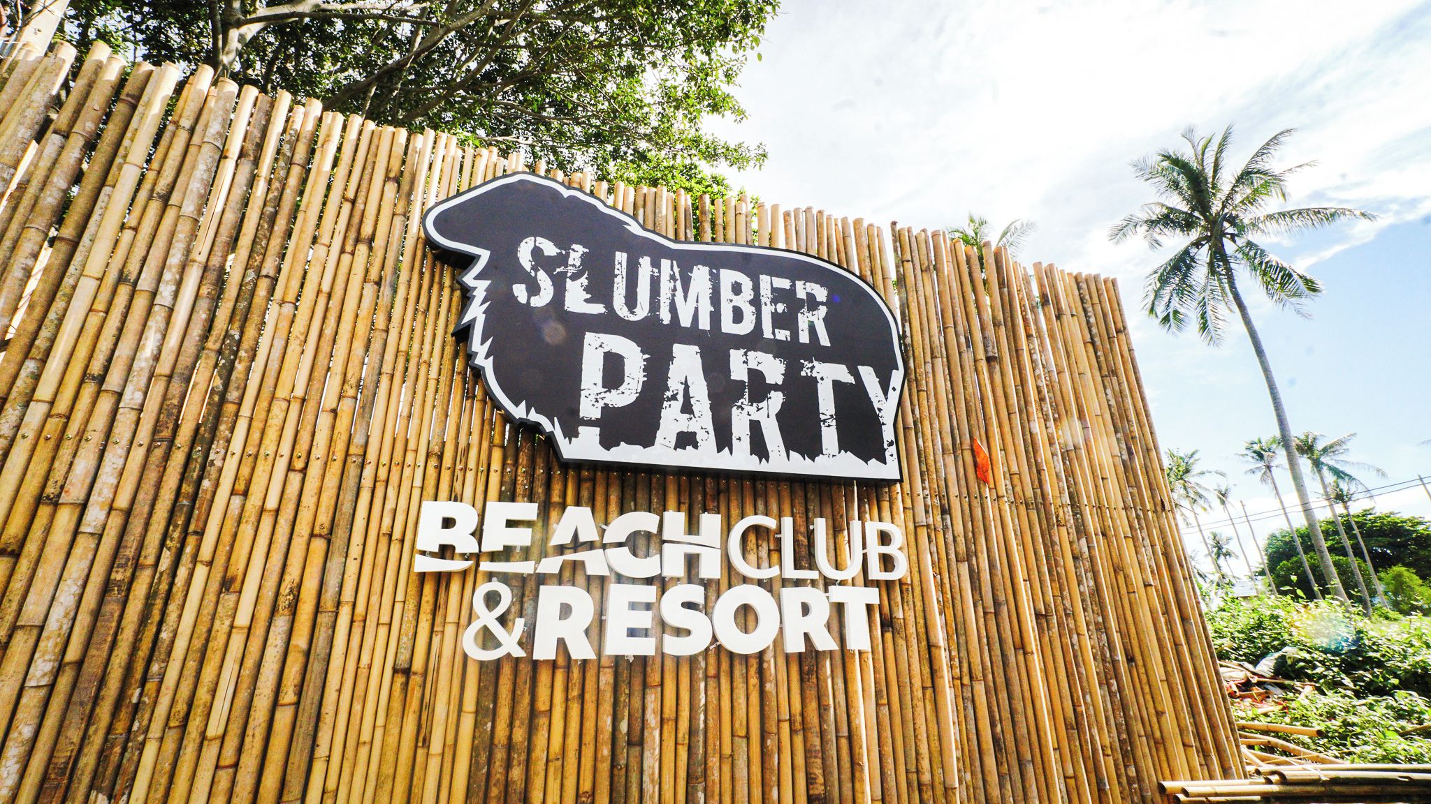 A sign for a 'Slumber Party' at a 'Beach Club & Resort'.