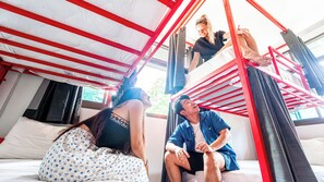 A room with a bunk bed, a window with curtains, and a bed with a floral-patterned cover. - Slumber Party Koh Phangan Beach (Ko Pha-ngan)