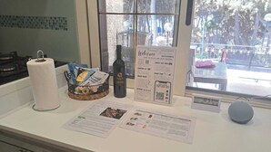 Un comptoir de cuisine avec un porte-essuie-tout, une bouteille de vin et des brochures d’information.