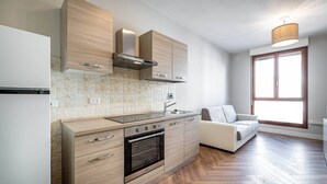 Eine moderne Küche mit Holzausstattung, einem eingebauten Backofen und einem großen Fenster für natürliches Licht.