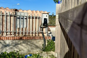 A security camera mounted on a fence, a brick wall, and a wooden structure.