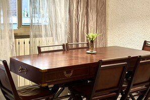 A conference table with chairs, a potted plant, and a window with curtains. - P031 - Porto Recanati, three-room apartment with terrace 100m from the sea (Porto Recanati)