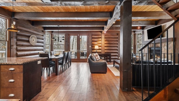 A log cabin interior with a dining area, a sofa, and a staircase. - At only 7 km from Mont-Tremblant Skiing,  Dream Chalet with Spa & Fireplace (Lac superieur)