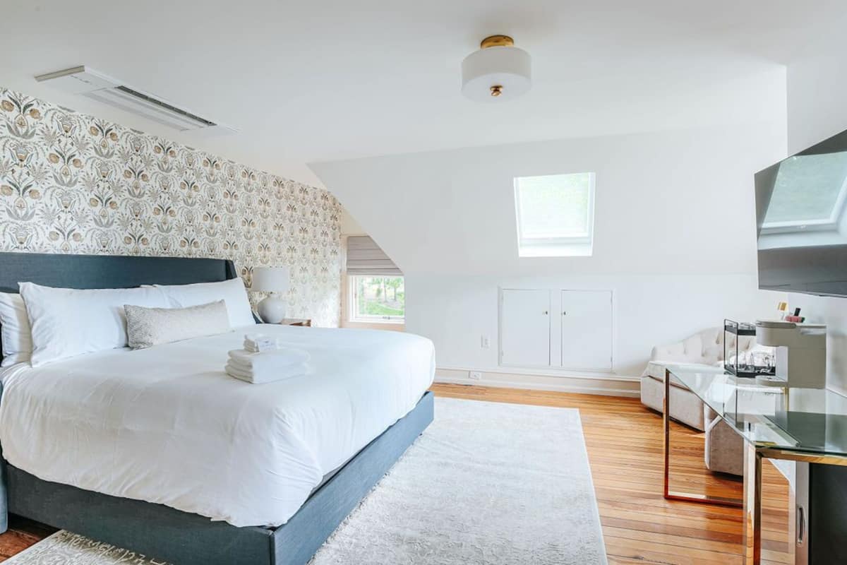 Ein modernes Schlafzimmer mit einem großen Bett, einem Schreibtisch und einem Fernseher.