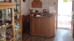 A reception area with wooden furniture, a bulletin board, and a clock on the wall. - Palm Hostal (Iquique)