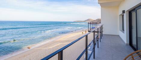 Een balkon met uitzicht op strand en zee.