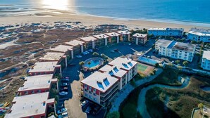 An aerial view of a coastal hotel with multiple buildings, a swimming pool, and a beach in the background. - Miele di North Myrtle Beach — 1st Floor, 2BR-2BA Condo @ Inlet Point Villas (North Myrtle Beach, SC)