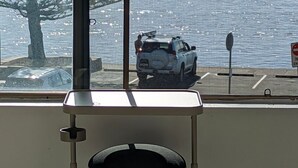A vehicle parked by a waterfront with a 'No Entry' sign visible. - Marine Parade - Ocean Views - Unit 6 (The Entrance)