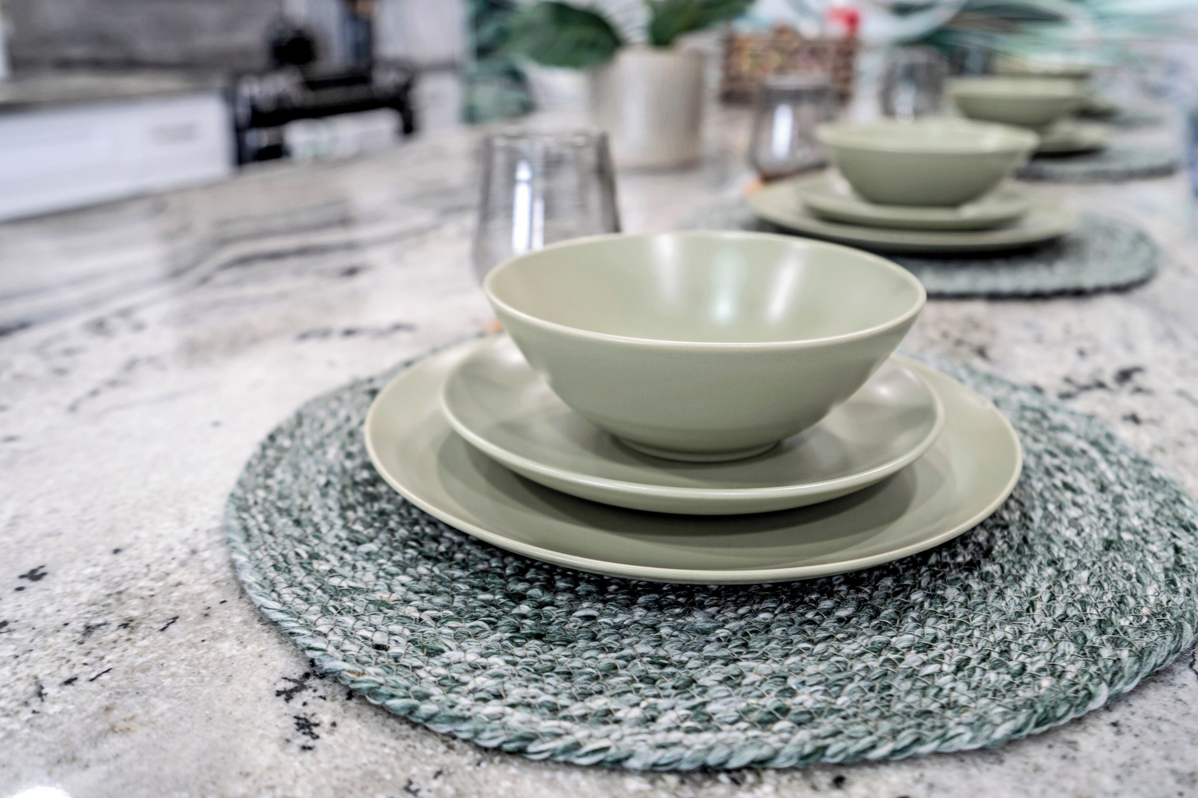 Un comptoir de cuisine avec un set de table en fibres tressées, un bol et une assiette.