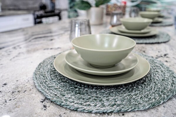 A kitchen counter with a woven placemat, a bowl, and a plate.