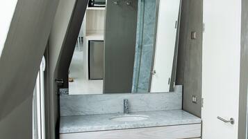 A bathroom with a marble sink, a large mirror, and a door with a handle.