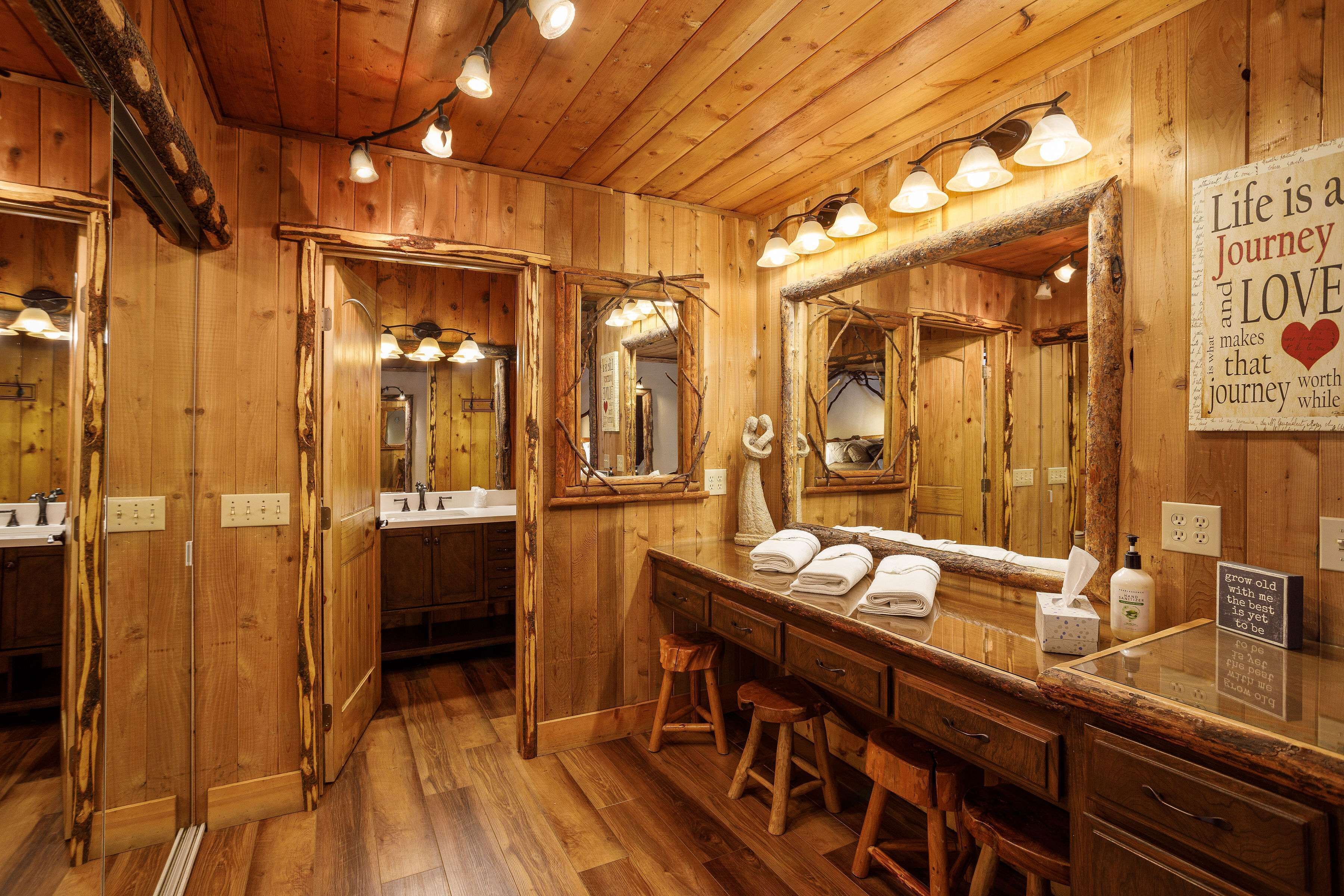 Un baño de madera con un espejo grande, varias luminarias y un letrero en la pared.