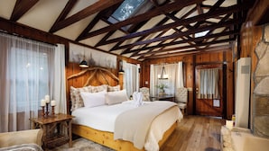 Un dormitorio acogedor con cama de madera, pared de piedra y un ventanal grande.