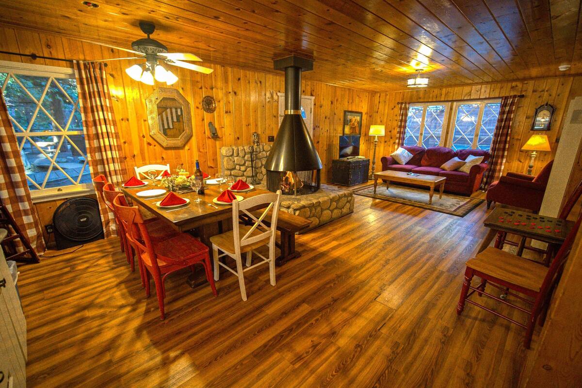 L’intérieur d’un chalet en bois comprend un coin repas, une cheminée et un salon confortable.