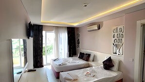Un dormitorio moderno con dos camas, un escritorio y un ventanal grande.
